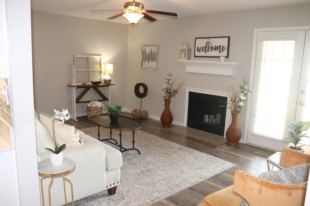 a living room with a white couch and a fireplace  at Laurelwood Apartment Homes, Laurel, MS, 39440