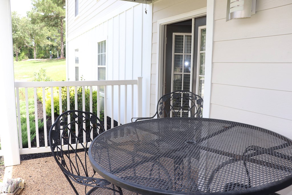 a patio with a table and chairs in front of a house  at Laurelwood Apartment Homes, Mississippi