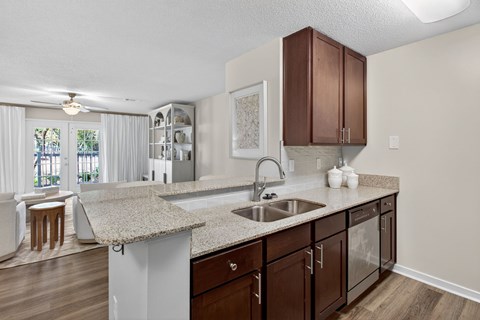 A kitchen with brown cabinets and a granite countertop.