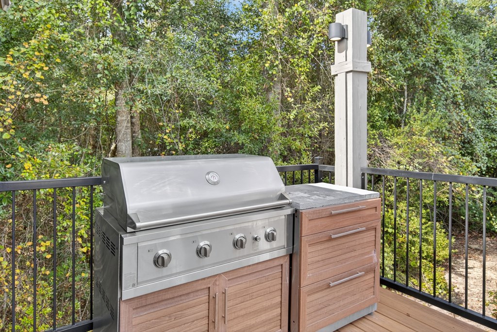 A stainless steel grill is on a wooden deck.
