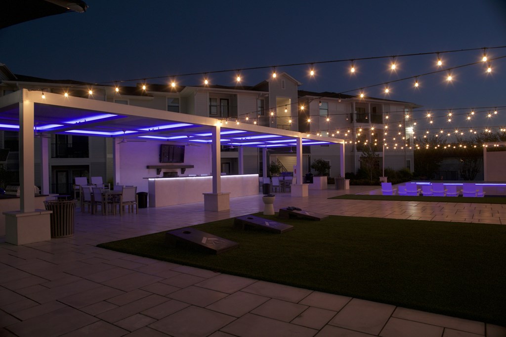 A patio area with a white pergola and string lights. at The Azul Apartment Homes, Oxford