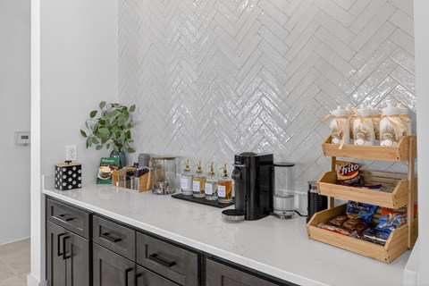 A kitchen counter with a black coffee maker and a wooden crate filled with snacks at Saltaire Apartment Homes in Santa Rosa Beach, Florida