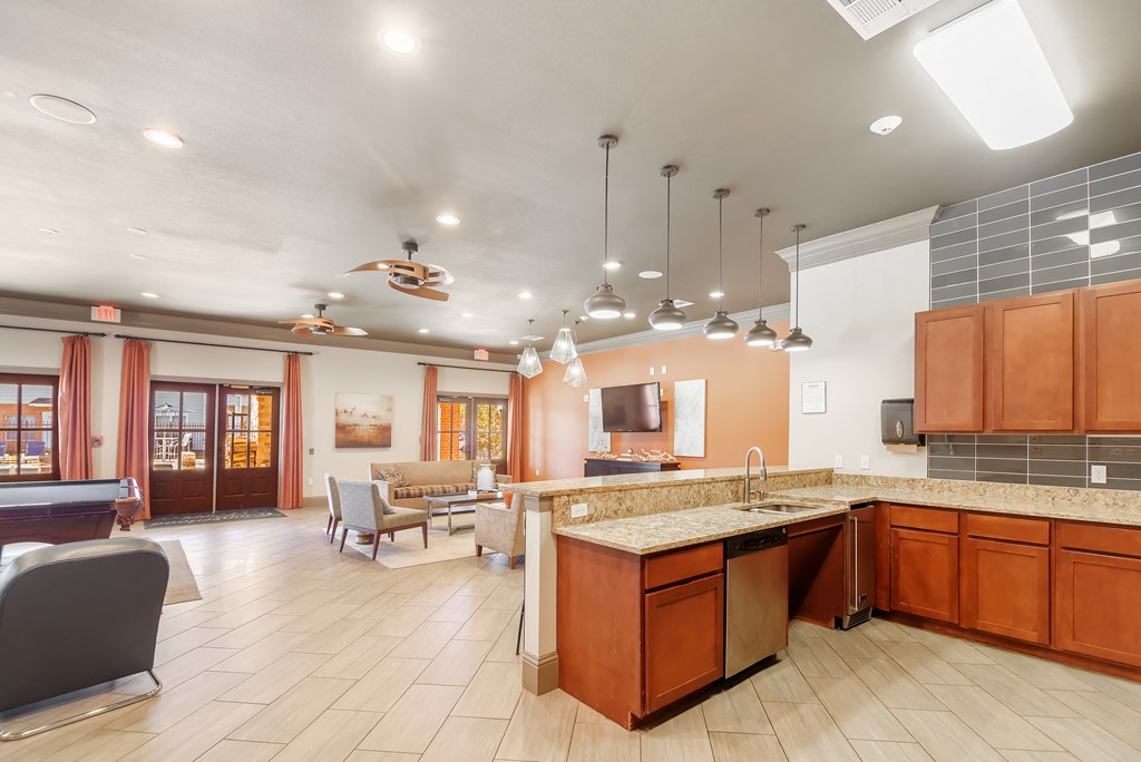 a clubhouse with a kitchen and a living room with a table and chairs at Cumberland Place Apartment Homes, Texas 75703