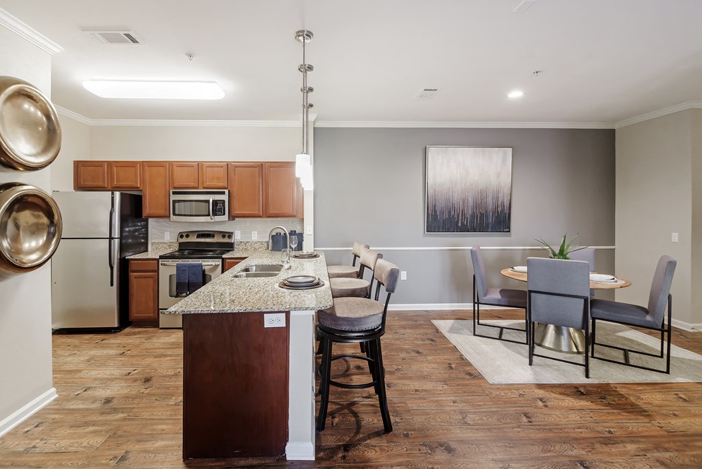 a kitchen and dining room area with a table and chairs at Cumberland Place Apartment Homes, Tyler, Texas