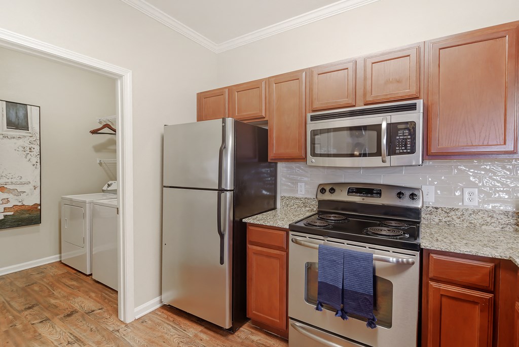 a kitchen with stainless steel appliances and wooden cabinets at Cumberland Place Apartment Homes, Tyler, TX 75703