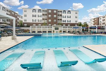 a large swimming pool with a building in the background at The Met Apartment Homes in Mississippi 39402