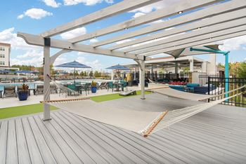 a deck with hammocks and umbrellas at the marina at watermark at The Met Apartment Homes in Hattiesburg, MS