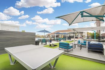 a rooftop patio with tables and chairs and umbrellas