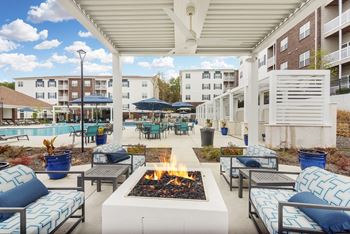 a rooftop patio with tables and chairs and umbrellas at The Met Apartment Homes in Hattiesburg, Mississippi