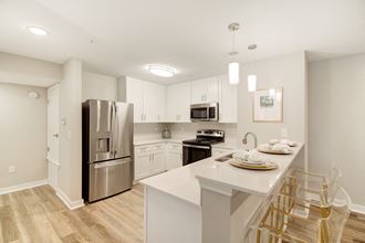 a kitchen with a large island and stainless steel refrigerator