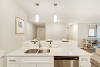 A modern kitchen with a white countertop and stainless steel appliances and dishwasher at The Azul Apartment Homes in Oxford, 38655