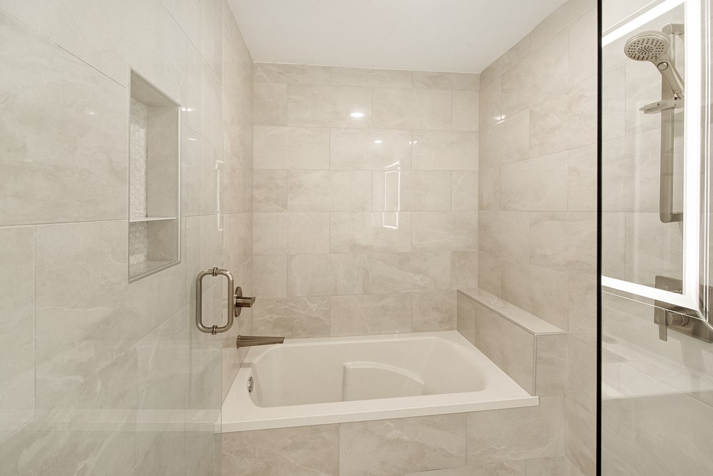 the ensuite bathroom has a tub and a shower at The Azul Apartment Homes in Oxford, MS 38655