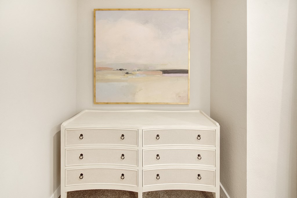 a white dresser with a painting on the wall above it at The Azul Apartment Homes in Oxford, Mississippi 38655