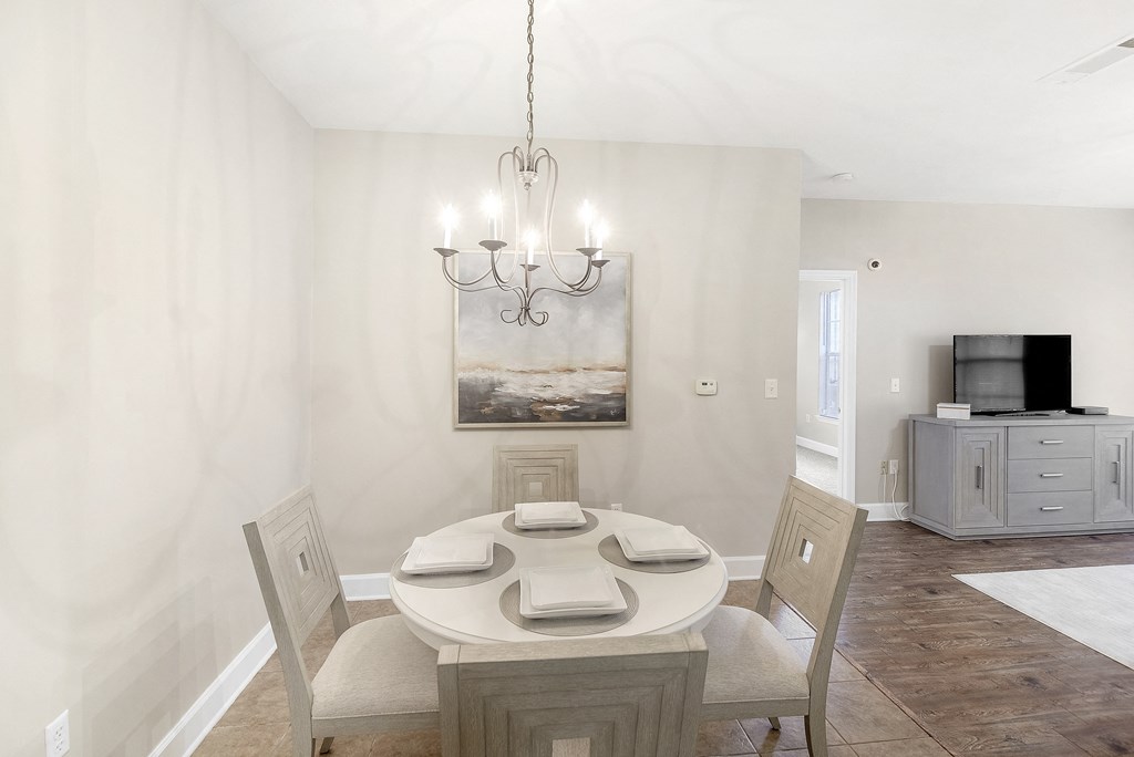 Dining room with a table and chairs and a chandelier at Highlands Apartment Homes, Bartlett, TN