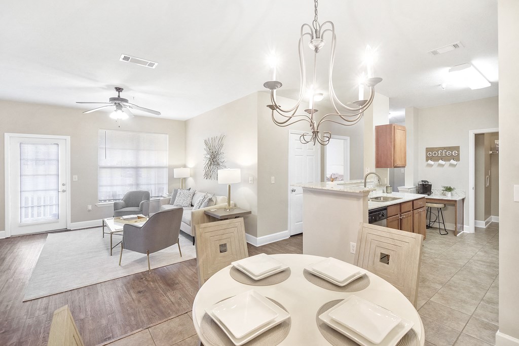 Living room with a dining room table and a kitchen at Highlands Apartment Homes, Bartlett, TN