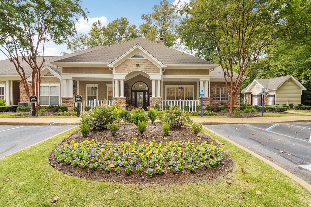 Front of a house with a flower garden in front of it at Highlands Apartment Homes, Bartlett