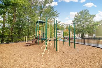 A playground with a green swing set and a yellow slide at Highlands Apartment Homes, Bartlett, Tennessee