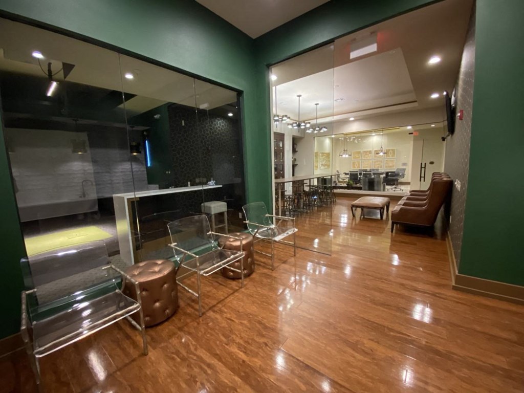 a large lobby with chairs and tables and a large window at The Retreat Apartment Homes in Williston, ND 58801