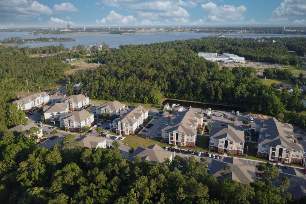 Arial view of a neighborhood of houses with a body of water in the background  at Lagniappe of Biloxi Apartment Homes, Biloxi, MS, 39532