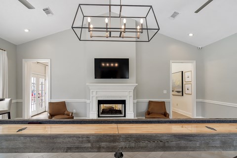 a living room with a fireplace and a table at Bridgewater Apartment Homes, Mississippi 39047