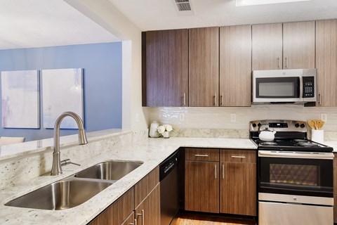 a modern kitchen with granite counter tops and wooden cabinets at Bridgewater Apartment Homes, Brandon, MS
