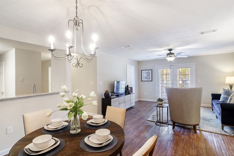 a dining room and living room with a table and chairs at Bridgewater Apartment Homes, Brandon, MS 39047