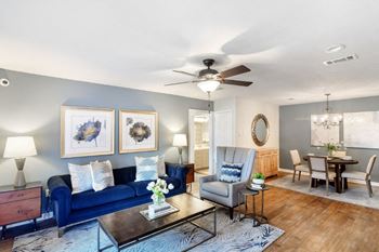 a living room with a blue couch and a ceiling fan at Bridgewater Apartment Homes, Brandon, 39047