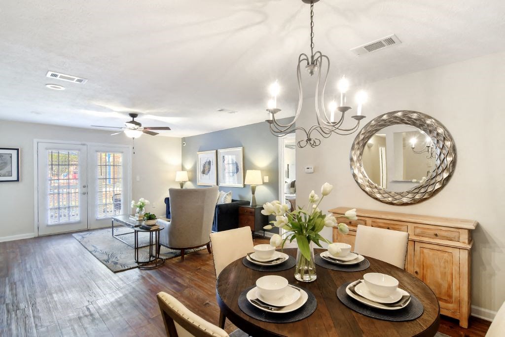 a dining room with a table and chairs and a chandelier  at Bridgewater Apartment Homes, Mississippi