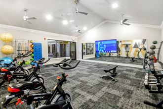 a home gym with a lot of bikes and a tv