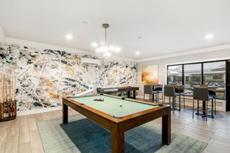 a pool table in a living room with tables and chairs