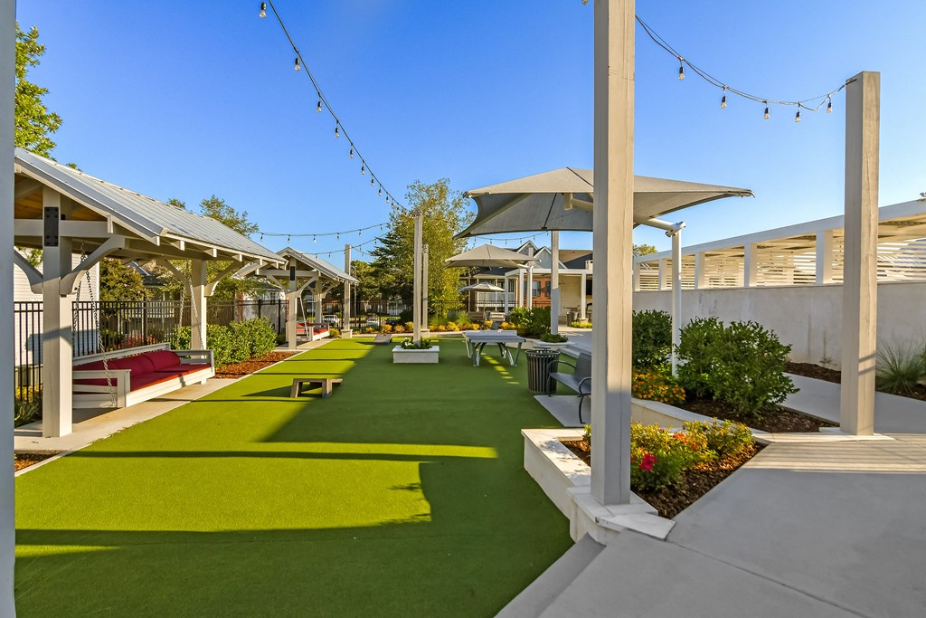 a courtyard with picnic tables and chairs and grass at Crossgates Apartment Homes, Starkville, MS
