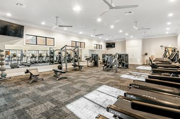A gym with a variety of equipment including treadmills, weights, and exercise machines at Crossgates Apartment Homes, Mississippi 39759