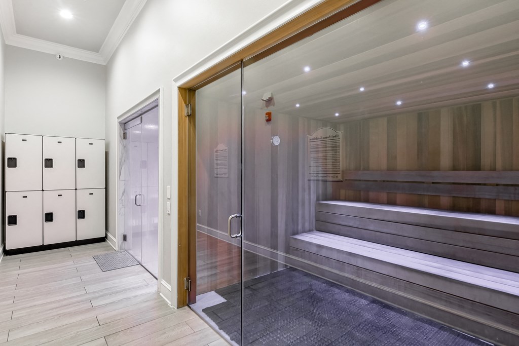 a large elevator lobby with a glass door and a bench in it at Crossgates Apartment Homes, Starkville, 39759