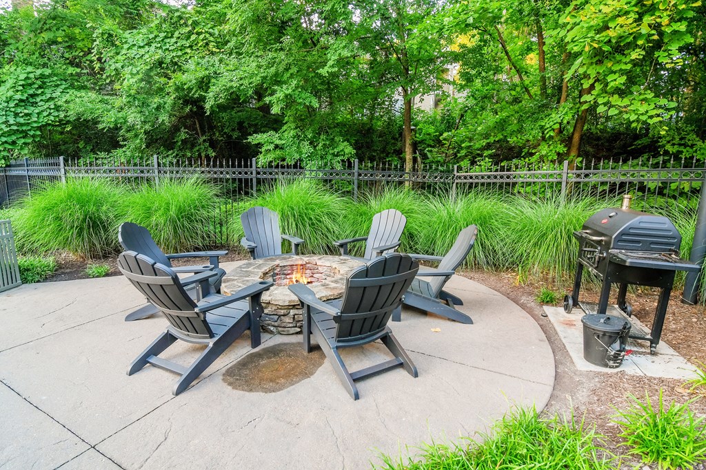 A fire pit surrounded by chairs in a backyard.