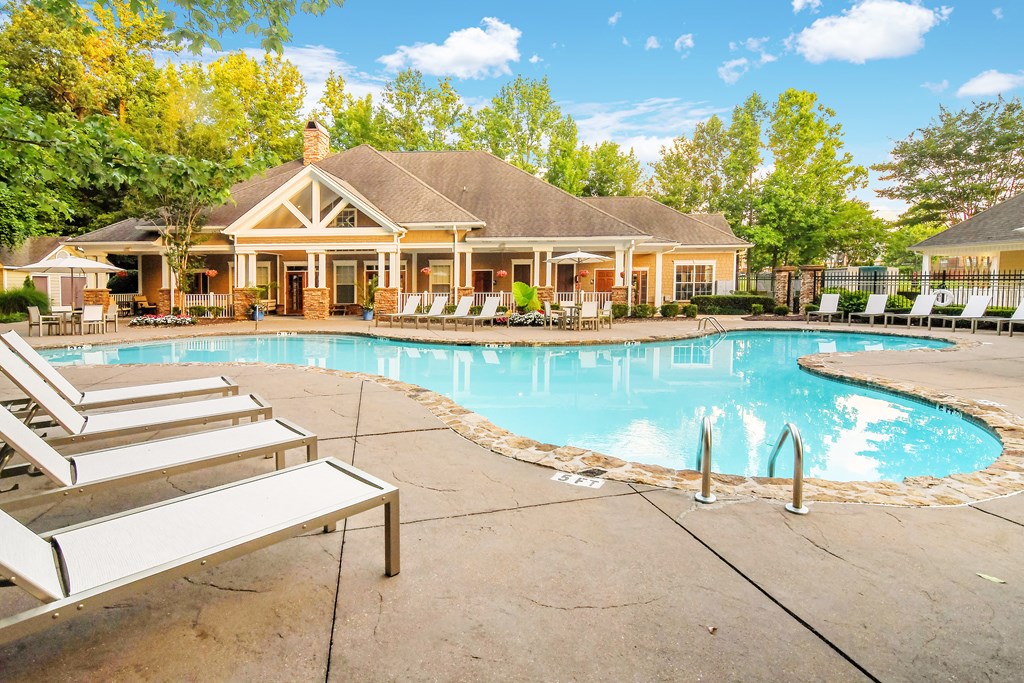 A house with a pool in front of it.