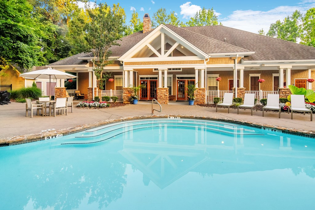 A house with a pool in front of it.