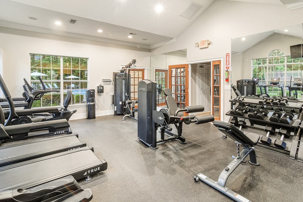 A gym with treadmills, weights, and exercise equipment.