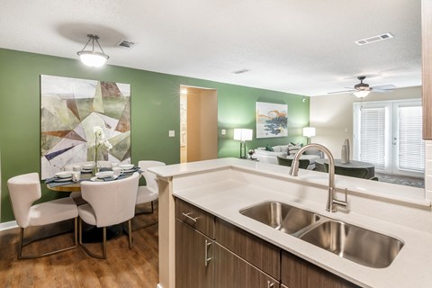 a kitchen with a sink and a dining room with a table and chairs at Crossgates Apartment Homes, Mississippi 39759