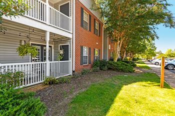 A red brick building with a white balcony at Crossgates Apartment Homes, Starkville, Mississippi