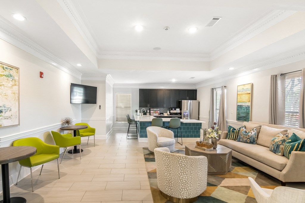 a living room with a couch and chairs and a kitchen at Avalon Apartment Homes in Starkville, Mississippi