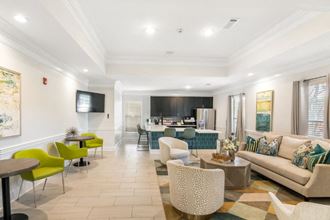 a living room with a couch and chairs and a kitchen