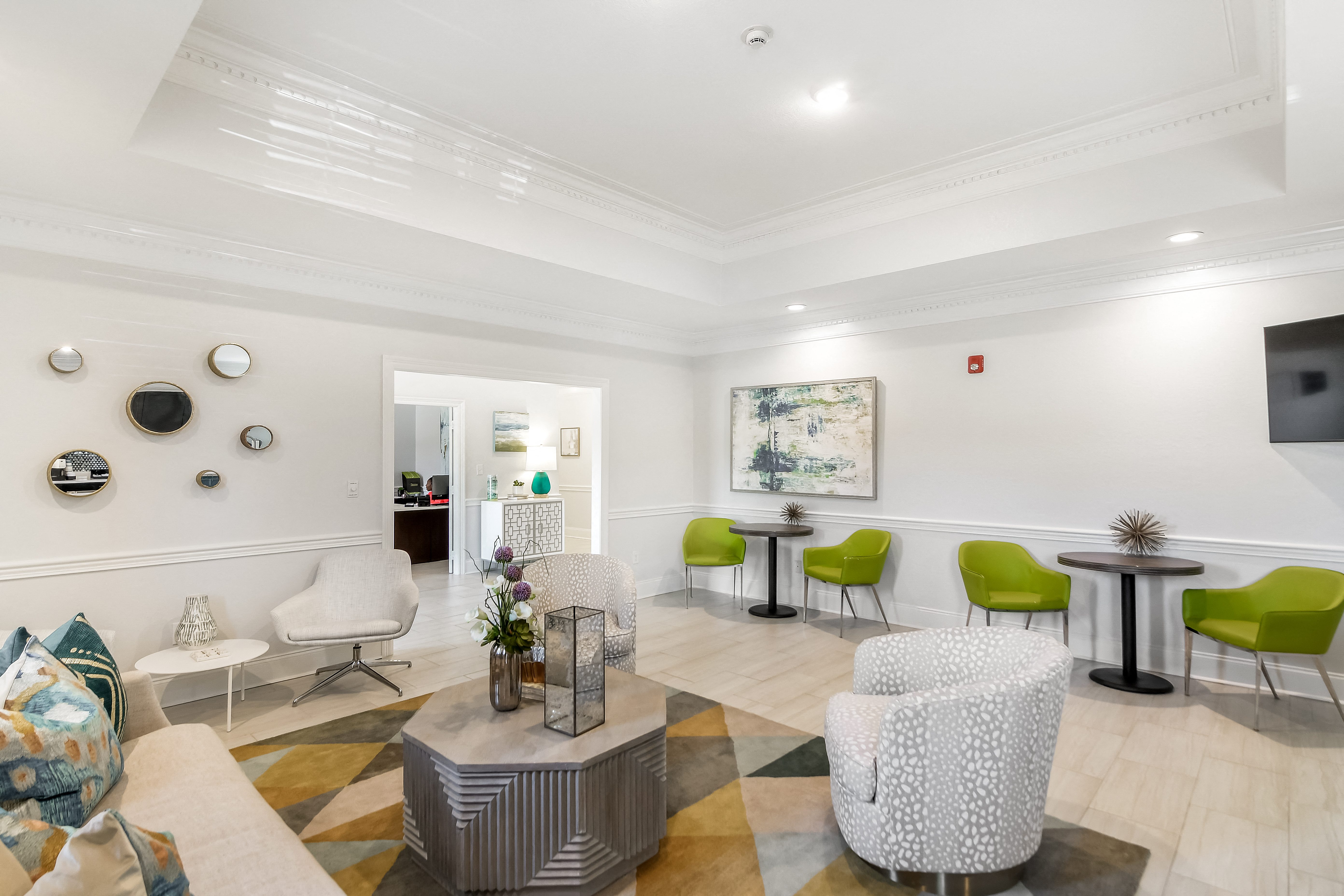 a living room with white walls and a checkered floor with chairs and tables