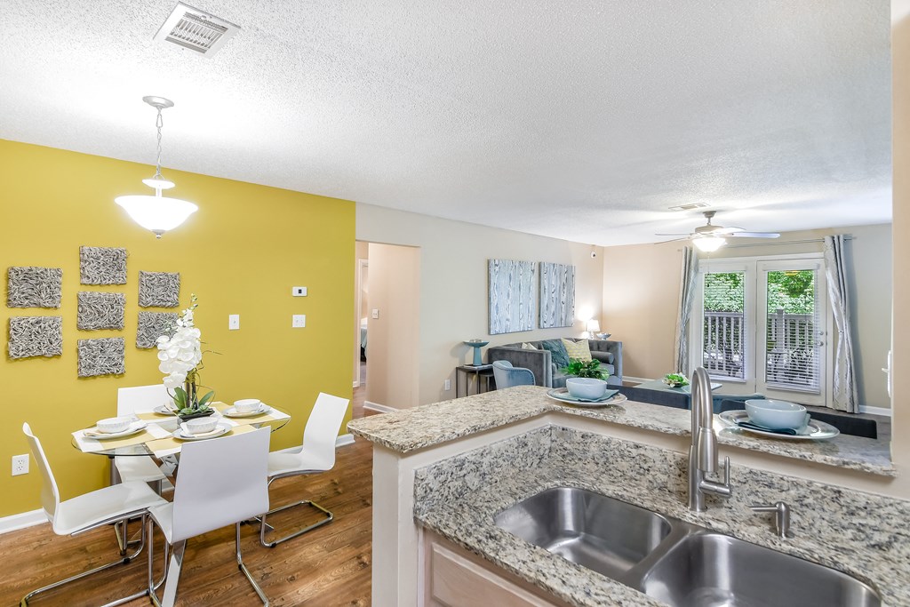 an open kitchen and dining room with a table and chairs at Avalon Apartment Homes in Starkville, Mississippi 39759