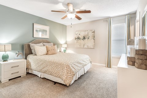 a bedroom with a bed and a ceiling fan at Avalon Apartments Starkville, MS