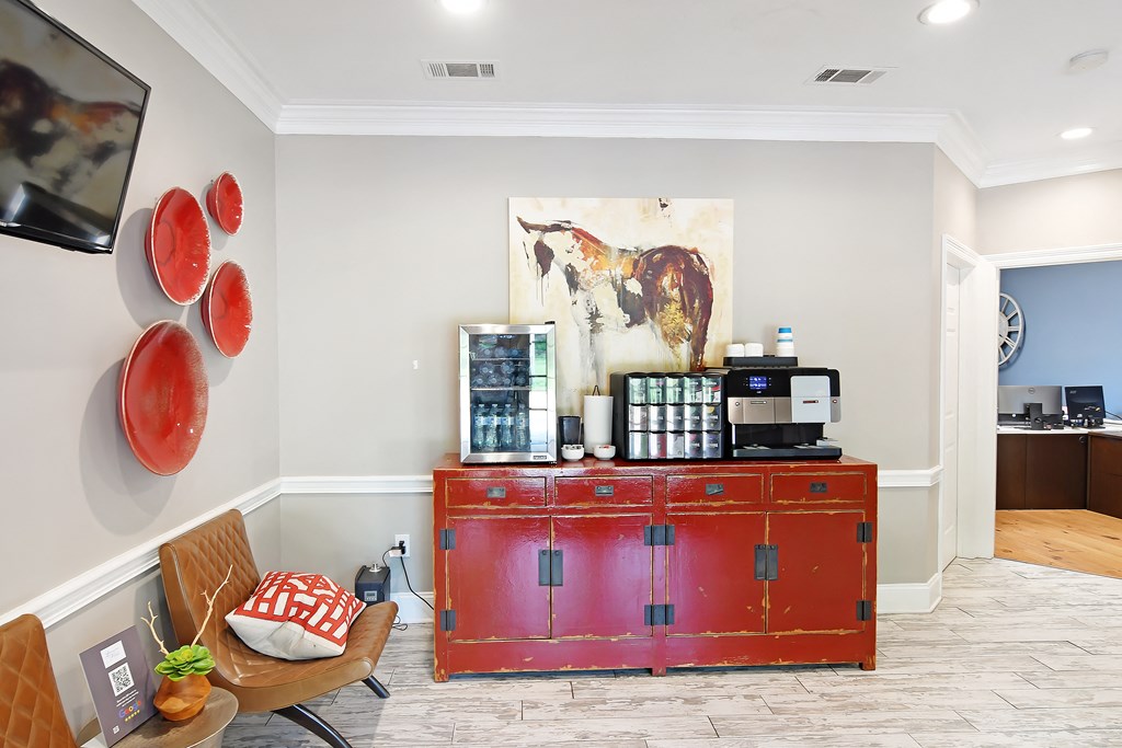 a living room with a red credenza and a coffee machine on top of it at Lexington Pointe Apartment Homes in Oxford, Mississippi