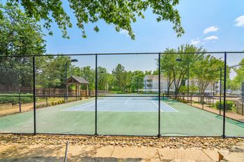 A tennis court surrounded by a black fence Lexington Pointe Apartment Homes in Oxford, Mississippi 38655