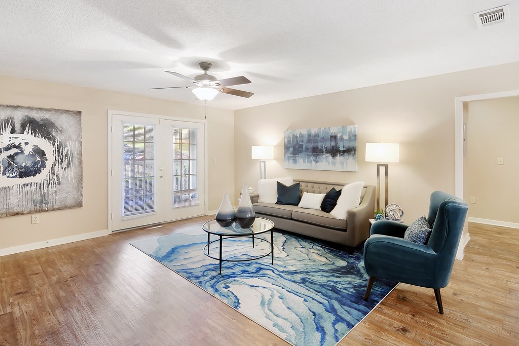a living room with a couch and a chair and a ceiling fan at Lexington Pointe Apartment Homes in Oxford, Mississippi