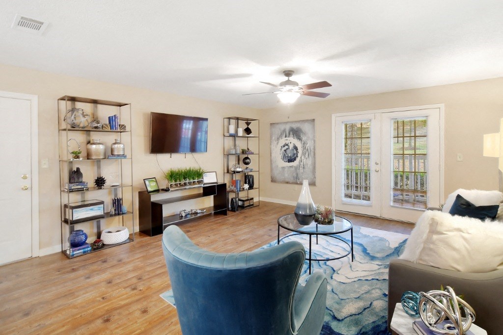 a living room with a ceiling fan and a tv on the wall at Lexington Pointe Apartment Homes, Oxford