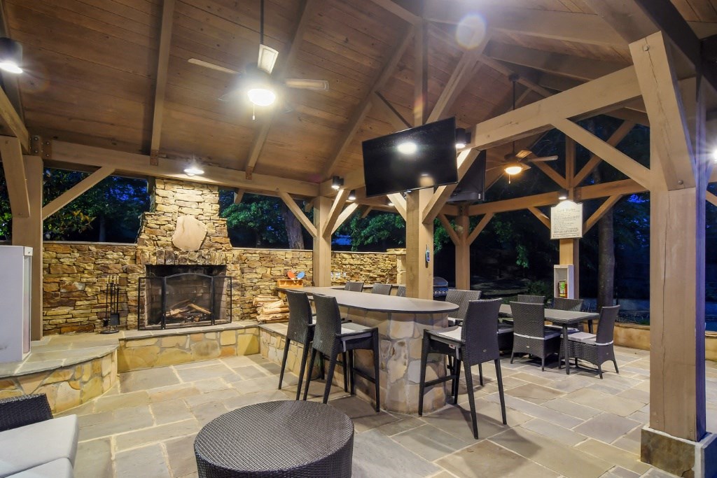 a covered patio with a fireplace and tables and chairs at Lexington Pointe Apartment Homes, Mississippi
