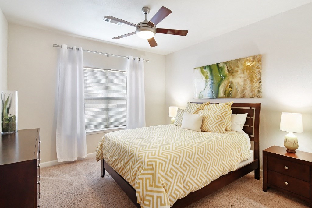 a bedroom with a large bed and a ceiling fan at Faulkner Flats Apartment Homes, Mississippi, 38655